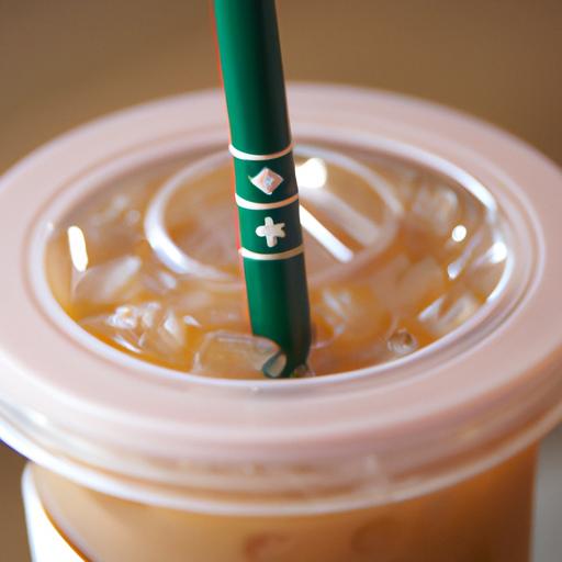 Gần gũi với ly cố định Starbucks đựng cafe đá và ống hút.
