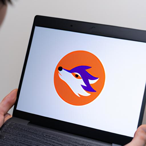 Người dùng giữ màn hình laptop hiển thị logo Firefox