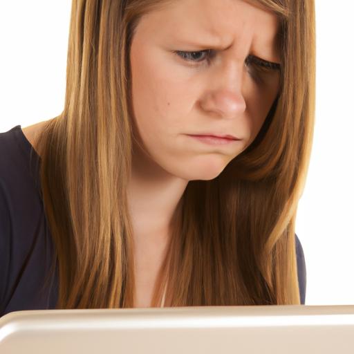 Một người đang gõ phím trên laptop với khuôn mặt buồn.